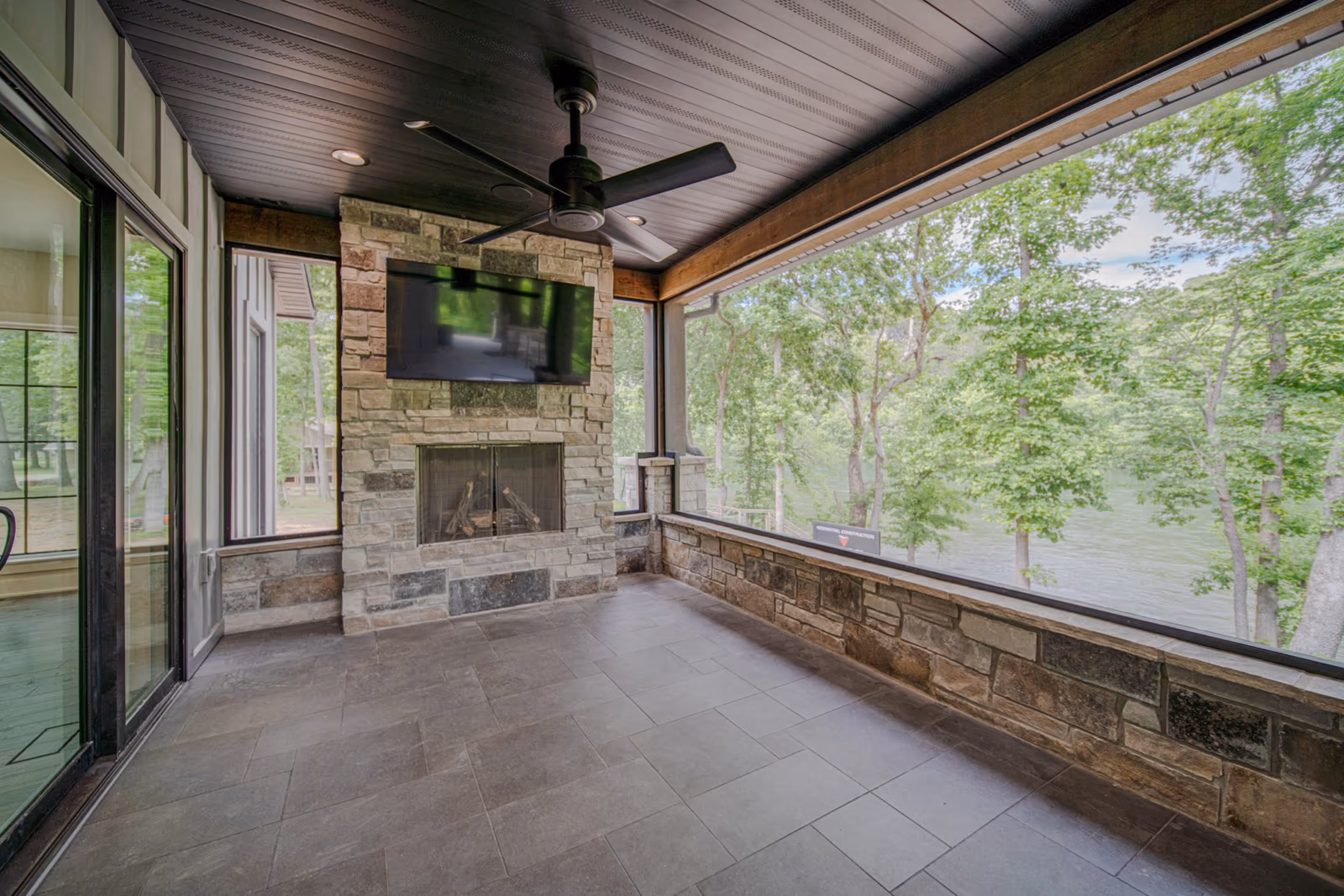 Screened porch with a stone fireplace at River Run on the White River