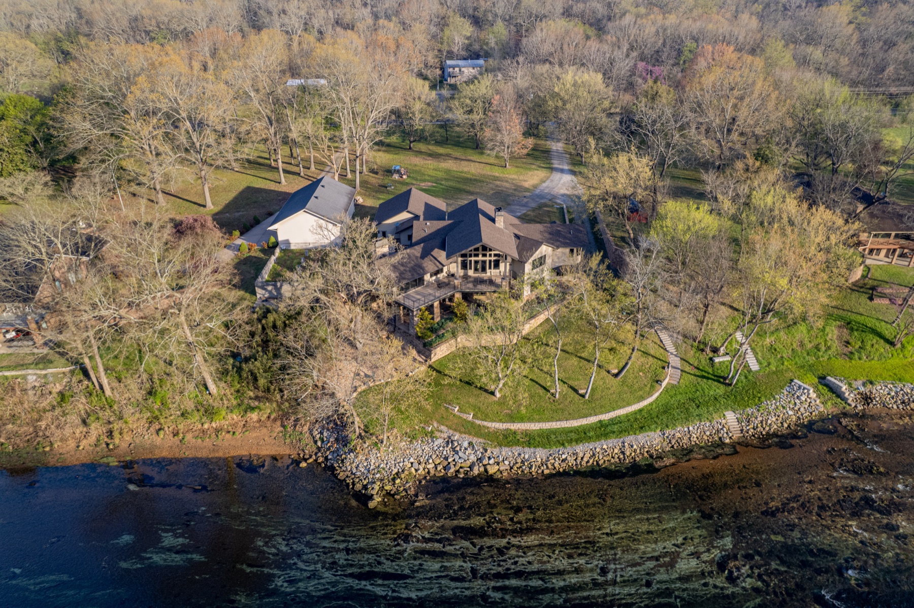 Aerial view of a custom estate along a rocky lakeshore